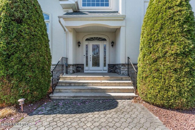 entrance to property featuring stone siding and stucco siding