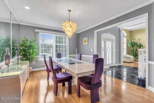 dining space with a healthy amount of sunlight, baseboards, a chandelier, and wood finished floors