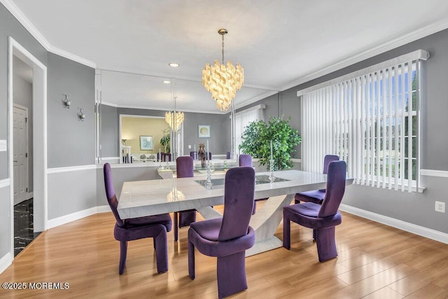 dining area with a chandelier, baseboards, crown molding, and wood finished floors