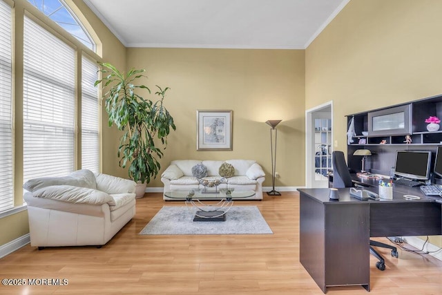 office area featuring ornamental molding, baseboards, and wood finished floors