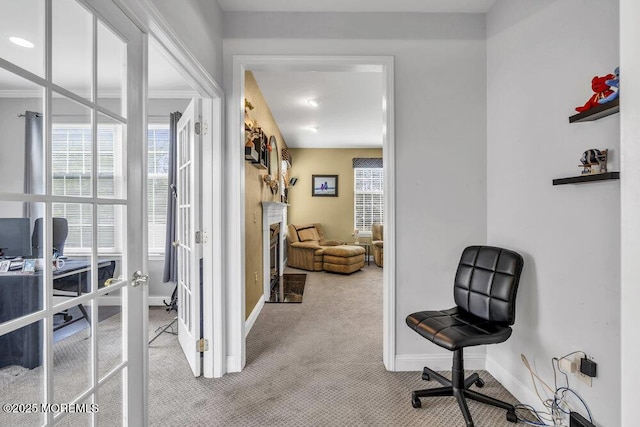 carpeted office space featuring french doors and baseboards