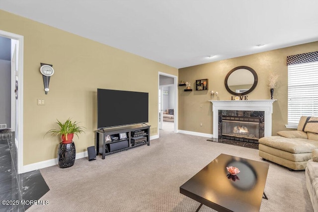 carpeted living room featuring baseboards and a premium fireplace