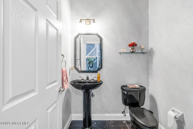 half bath with toilet and baseboards