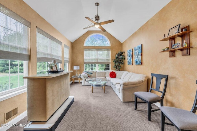 living area with visible vents, a ceiling fan, plenty of natural light, and light carpet