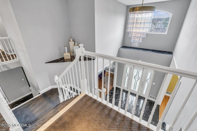 staircase with a high ceiling and baseboards