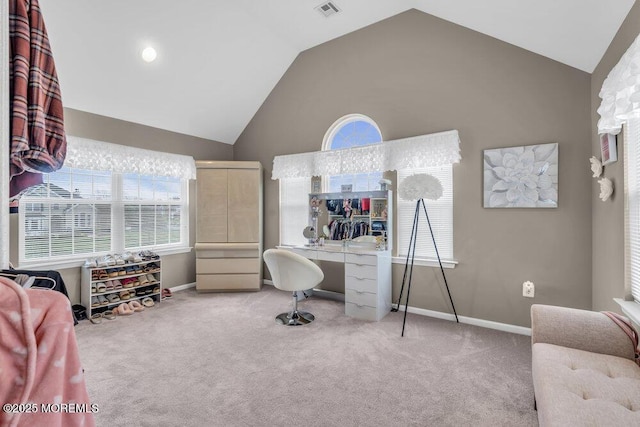carpeted office space with high vaulted ceiling, visible vents, and baseboards