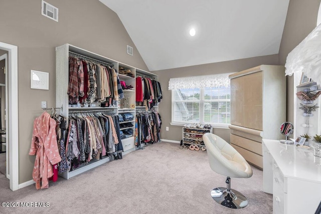 spacious closet featuring visible vents, high vaulted ceiling, and carpet floors