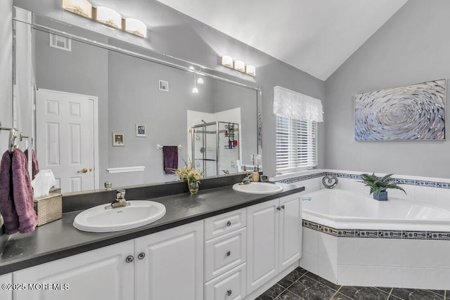 full bathroom with double vanity, vaulted ceiling, and a sink