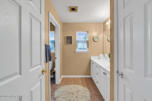bathroom featuring toilet, tile patterned floors, vanity, and baseboards