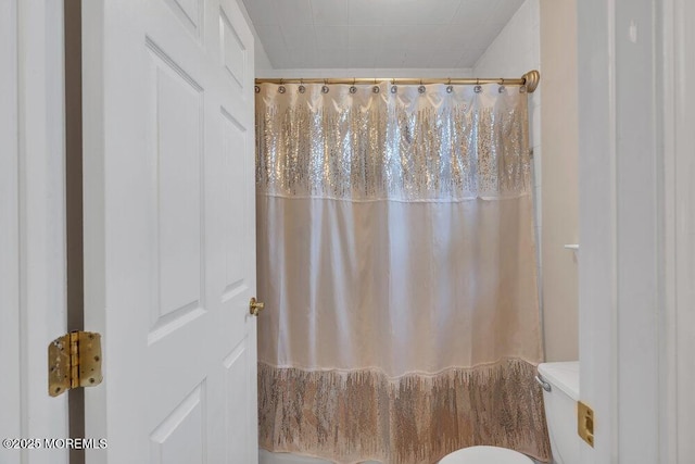 full bath featuring toilet and a shower with curtain