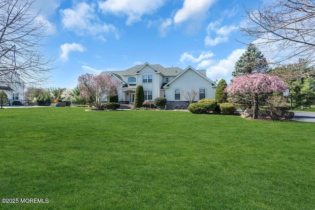 view of front of home with stucco siding and a front lawn