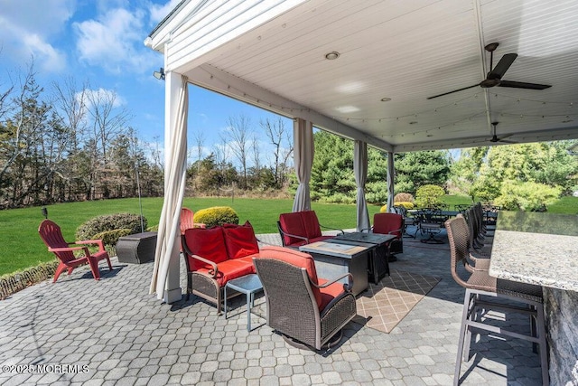 view of patio / terrace with ceiling fan and a fire pit