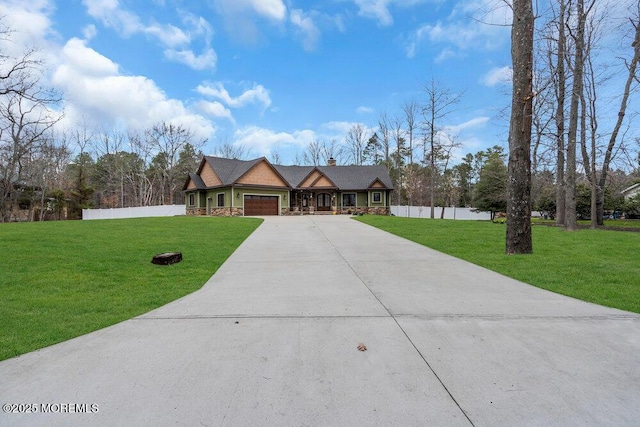 view of front facade featuring a garage, a front lawn, fence, and concrete driveway