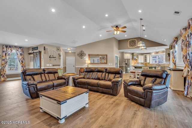living area with light wood-type flooring, recessed lighting, a ceiling fan, visible vents, and high vaulted ceiling