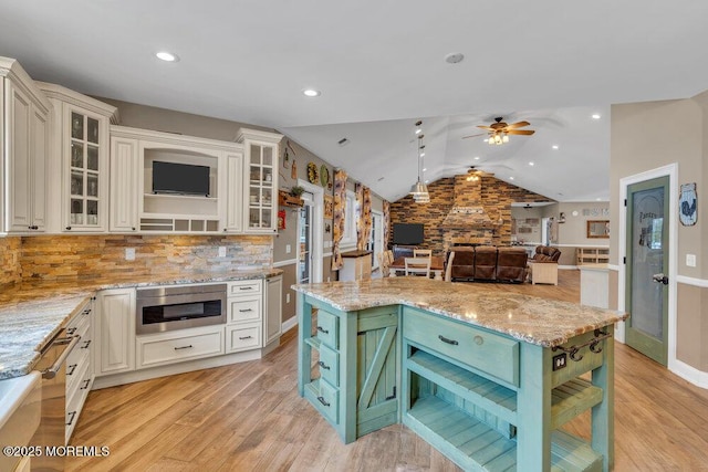 kitchen featuring light wood-style floors, open shelves, vaulted ceiling, and a ceiling fan