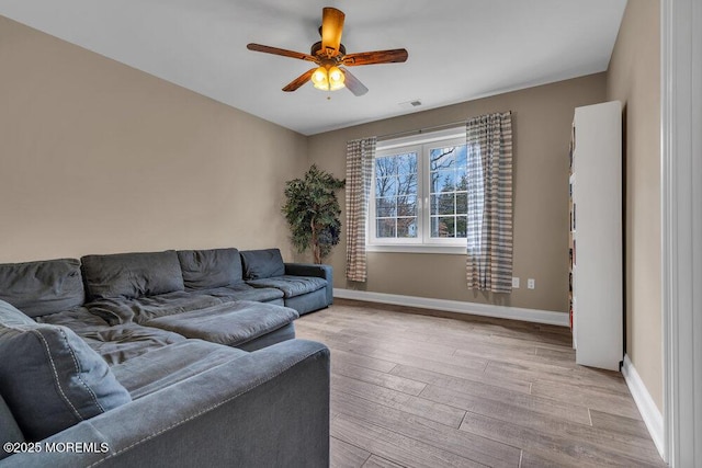 living room with visible vents, baseboards, light wood-type flooring, and a ceiling fan