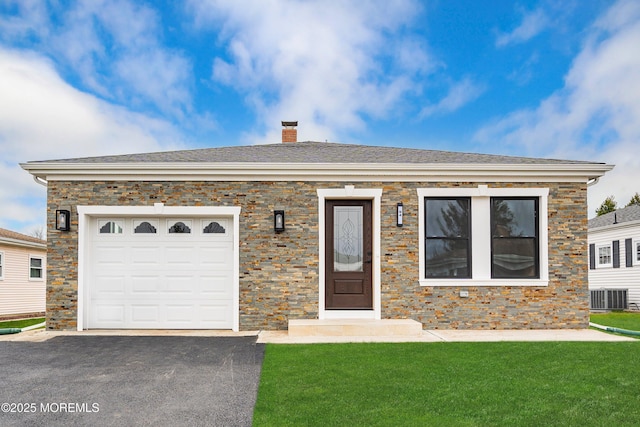single story home featuring a front yard, an attached garage, a chimney, central air condition unit, and driveway