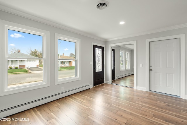 entrance foyer with baseboard heating, visible vents, and ornamental molding