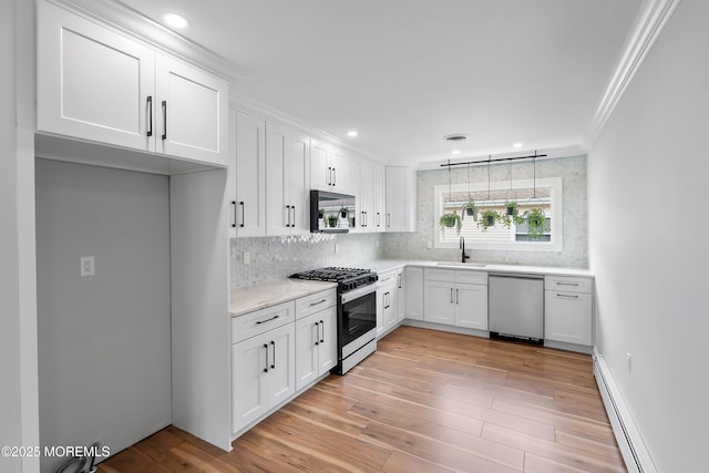 kitchen with dishwasher, a sink, a baseboard radiator, crown molding, and range with gas stovetop
