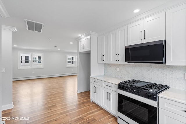 kitchen with baseboard heating, gas range oven, visible vents, and white cabinetry