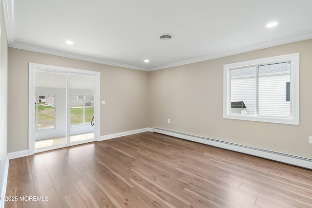 spare room featuring crown molding, visible vents, a baseboard heating unit, and wood finished floors