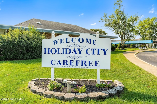 community / neighborhood sign featuring a lawn