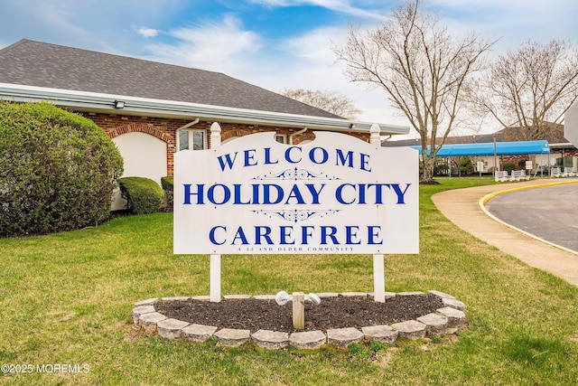 community sign featuring a lawn
