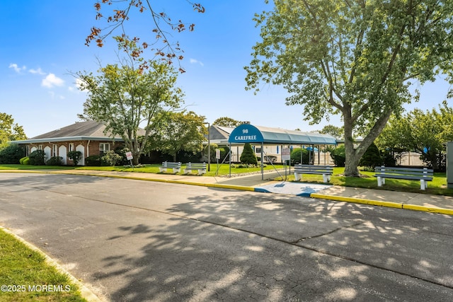 view of front facade featuring uncovered parking and a front yard
