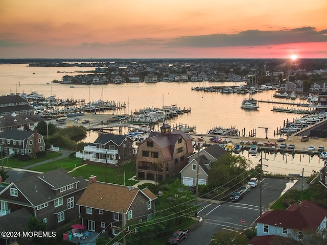 aerial view at dusk featuring a water view