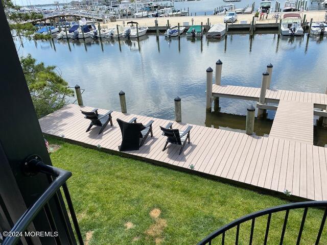 dock area with a water view and a yard