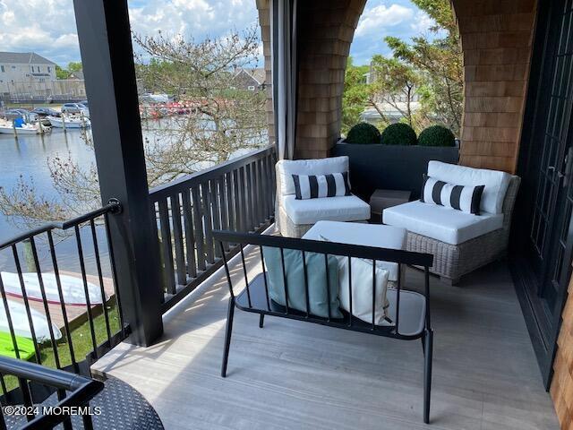 balcony featuring a water view and outdoor lounge area