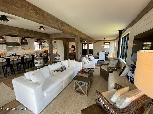 living area featuring beamed ceiling and wood finished floors