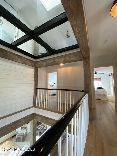corridor with beam ceiling and wood finished floors