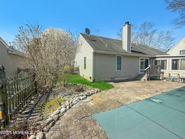 back of house with a patio, fence, and a chimney