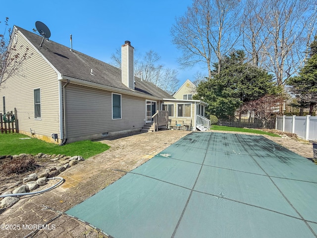 rear view of property with a patio, a chimney, entry steps, a yard, and fence