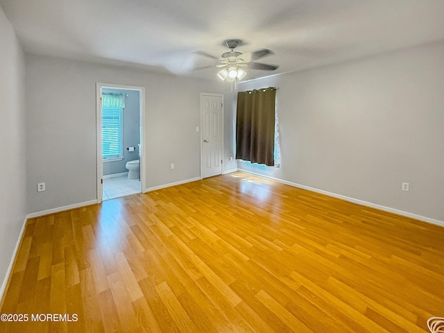 spare room featuring light wood finished floors, visible vents, baseboards, and ceiling fan