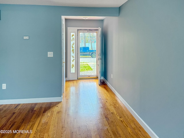interior space with baseboards and wood finished floors