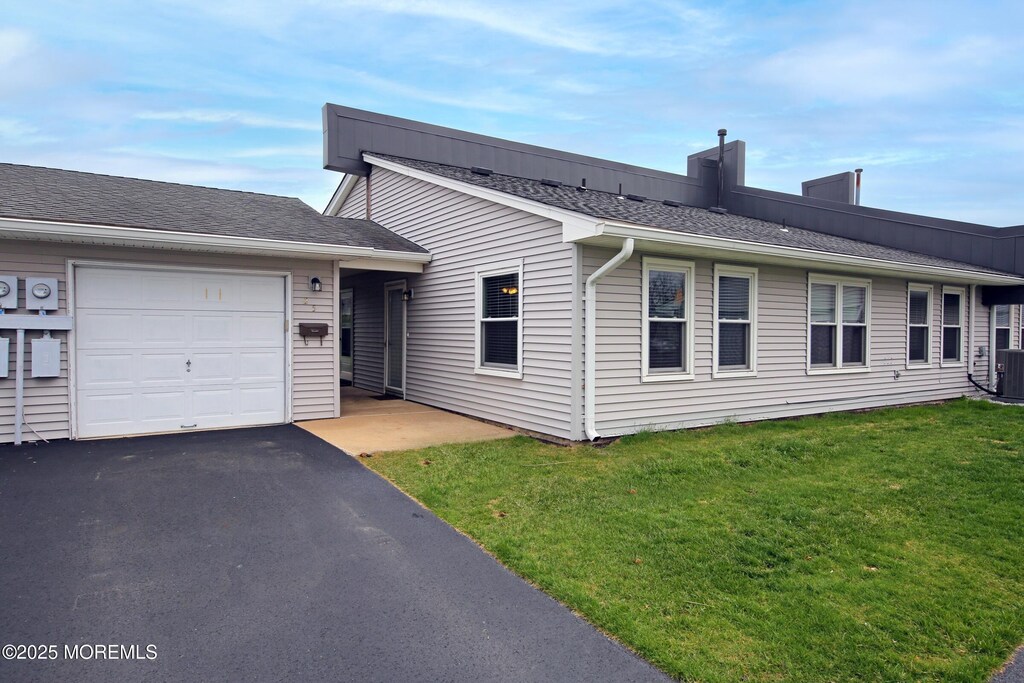 view of front of property with a garage, driveway, and a front lawn