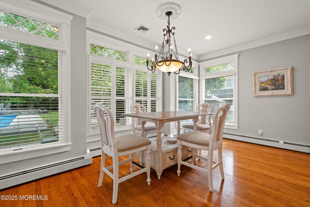 491 Clinton Ave, Toms River, NJ 08753 - dining room featuring a chandelier, ornamental molding, a baseboard heating unit, and light wood finished floors