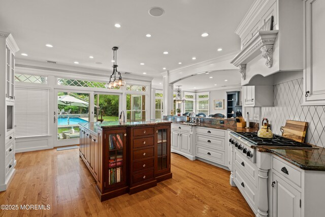 491 Clinton Ave, Toms River, NJ 08753 - kitchen featuring crown molding, stainless steel gas stovetop, glass insert cabinets, a peninsula, and white cabinetry