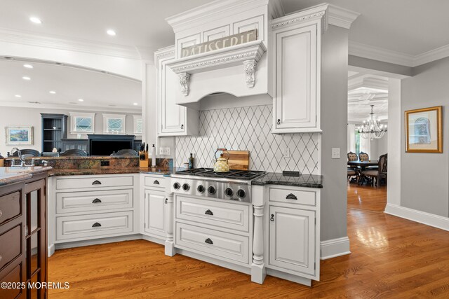 491 Clinton Ave, Toms River, NJ 08753 - kitchen with stainless steel gas stovetop, a chandelier, backsplash, light wood-style floors, and recessed lighting