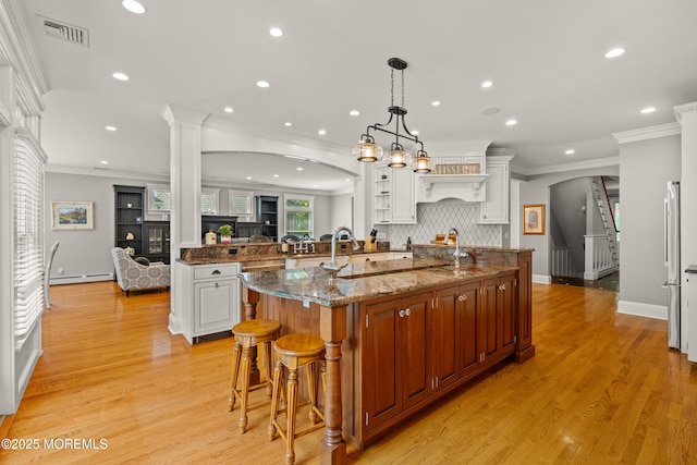 491 Clinton Ave, Toms River, NJ 08753 - kitchen featuring a kitchen island with sink, a baseboard heating unit, crown molding, light wood-style flooring, and recessed lighting