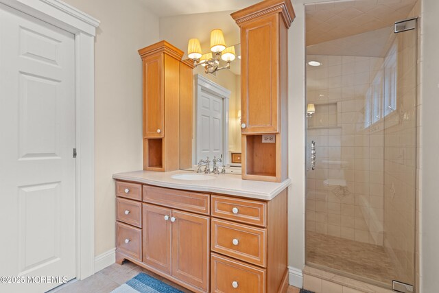 491 Clinton Ave, Toms River, NJ 08753 - bathroom featuring a stall shower, vanity, a chandelier, baseboards, and tile patterned flooring