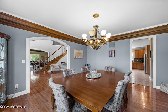 5 Breckenridge Ct, Freehold, NJ 07728 - dining area with an inviting chandelier, stairway, baseboards, visible vents, and arched walkways