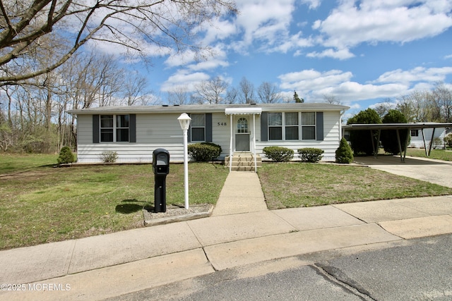 view of front of property with a carport, driveway, and a front yard