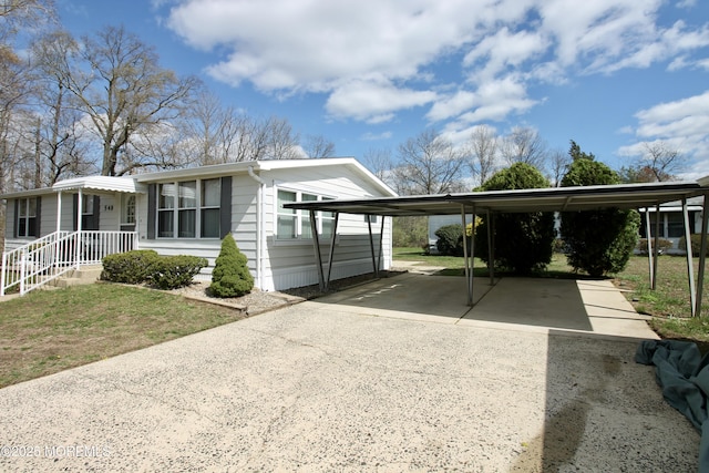 view of side of home with a carport, a lawn, and concrete driveway