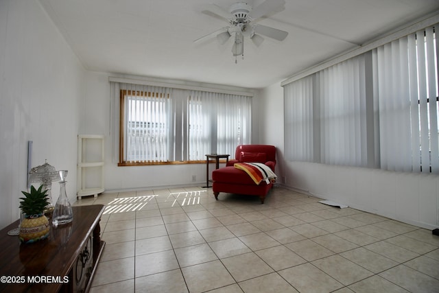 living area with light tile patterned floors and a ceiling fan