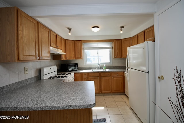 kitchen featuring a toaster, white appliances, under cabinet range hood, decorative backsplash, and a sink
