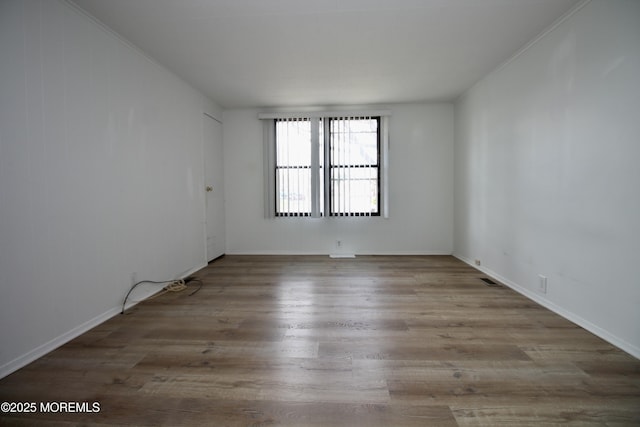 unfurnished room featuring baseboards and wood finished floors