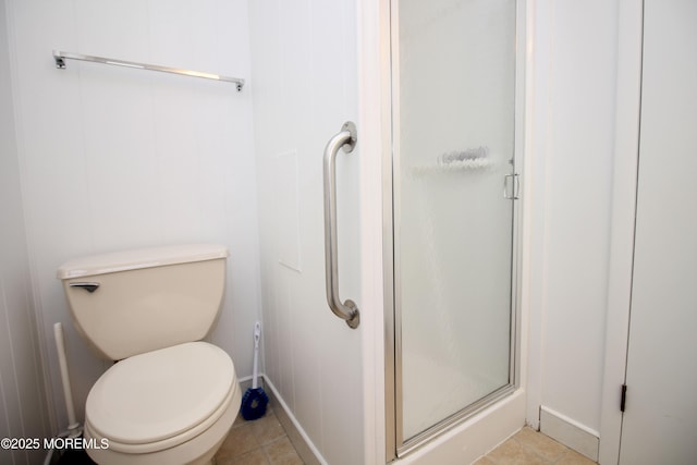 full bathroom featuring toilet, a stall shower, and tile patterned flooring